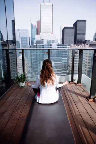 files/person-faces-the-city-while-sitting-on-a-yoga-mat-on-a-balcony.jpg